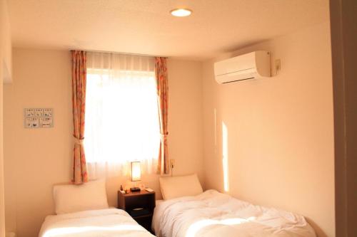 a small room with two beds and a window at Irodorinoyado Kaede Izumi - Vacation STAY 70069v in Yamanakako