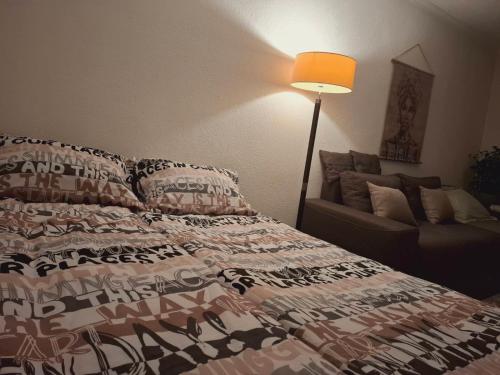 una camera da letto con un letto, una lampada e un divano di Stan-apartman A&A a Banja Luka