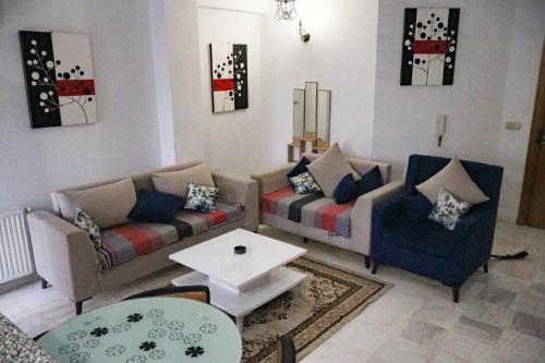 a living room with two couches and a table at Appartement a Kantaoui in Port El Kantaoui