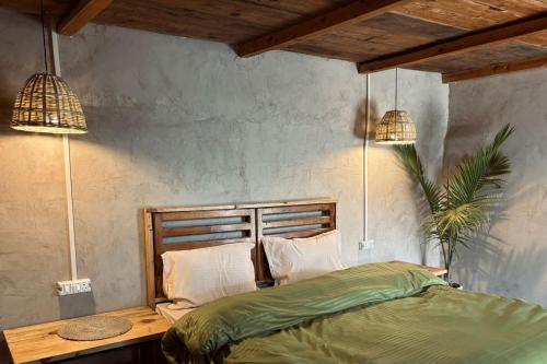 a bedroom with two pendant lights and a bed at #middleofnowehere Pahadi Homestay by Mon Stays in Dhanaulti