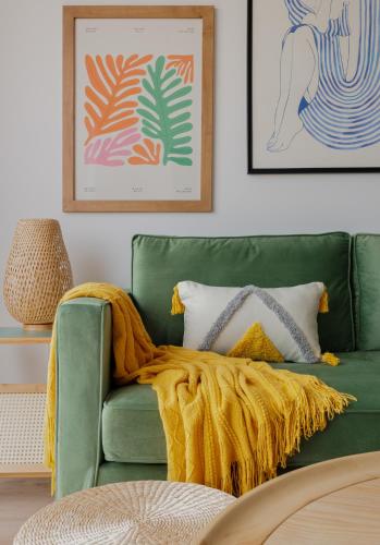a green couch with a blanket on it in a living room at way2sun penthouses Gran Alacant - FREE e-bikes & jacuzzi & solarium & PS5 in Gran Alacant