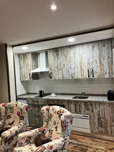 a kitchen with two chairs in front of a mirror at Los Nidos de Nines in Cabezabellosa