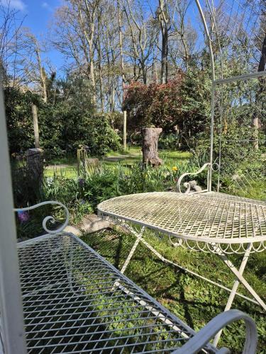 a table and a bench in a park at Gingerbread Cottage Yurts in East Dereham
