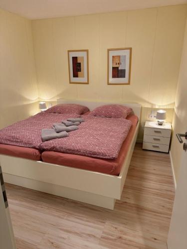 a bedroom with a bed with red comforter at Weinmanns Wildgatter in Grafenwiesen