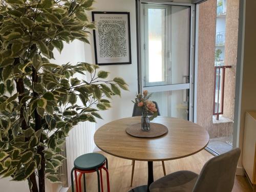 une salle à manger avec une table et une plante dans l'établissement Botanic Escape with Air Con, Balcony & Candle Bath Ritual - Pets Welcome, à Carcassonne