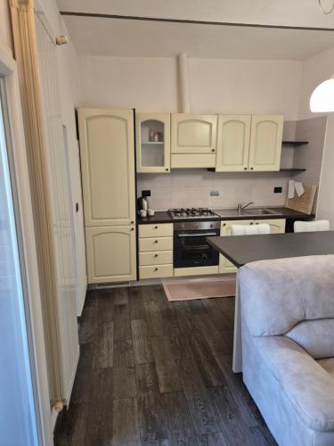 a kitchen with white cabinets and a couch at 20 Minutes to FLORENCE in Prato