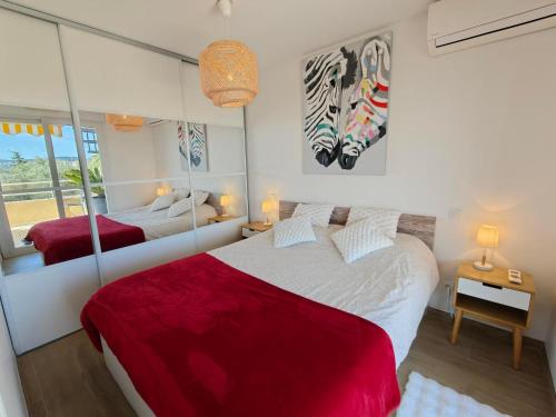 a bedroom with two beds and a mirror at Appartement toit terrasse Nice-ouest avec parking, clim et piscine in Nice