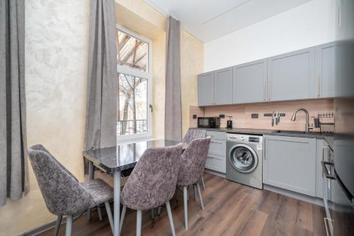une cuisine avec une table et des chaises ainsi qu'un lave-linge dans l'établissement Stylish property, Self check in 24h, Netflix, parking, à Vilnius