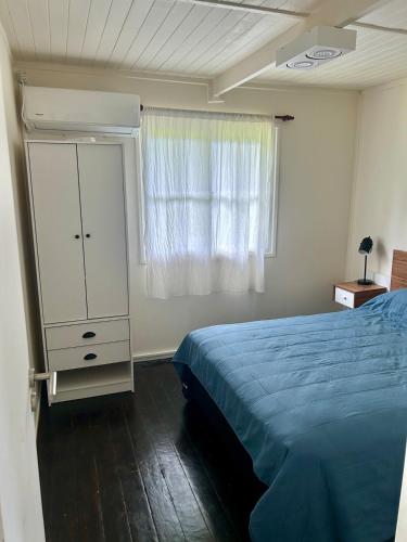 a bedroom with a bed and a dresser and a window at Las Luciérnagas del Delta 1 in Tigre