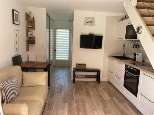 un salon avec un canapé et une cuisine dans l'établissement LES MAISONS DE LA MER, PLAGE A PIEDS, à Piriac-sur-Mer