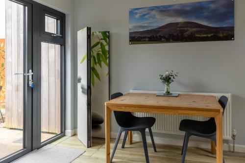 a dining room table with two chairs and a painting on the wall at Welsh Marches at Upper Glyn Farm in Chepstow