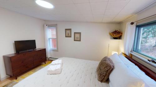 a bedroom with a bed and a flat screen tv at Winter Lore in Mendon