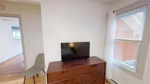 a flat screen tv sitting on top of a wooden dresser at Winter Lore in Mendon