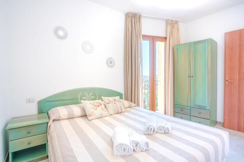 a bedroom with a large bed with shoes on it at Appartamenti Le Maree in La Maddalena