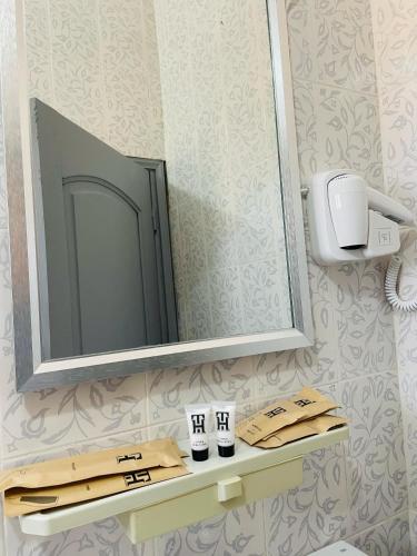 a bathroom with a mirror and two towels on a shelf at Les HOTELS TALHAYA, NOUAKCHOTT in Nouakchott