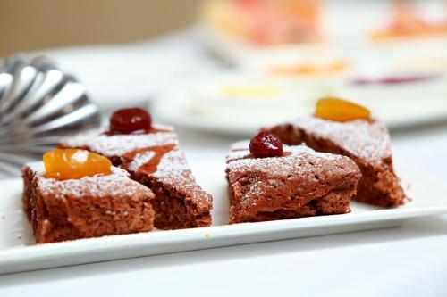 a plate of brownies with fruit and powdered sugar at Soluxe Hotel in Bishkek