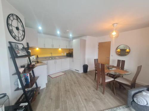 cocina y comedor con reloj en la pared en Apex Appartments, en Ifield