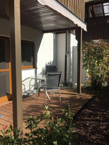 a patio with a table and chairs on a deck at Weinmanns Wildgatter in Grafenwiesen