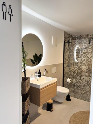 a bathroom with a sink and a toilet and a mirror at WeinZeit13 in Neustadt an der Weinstraße