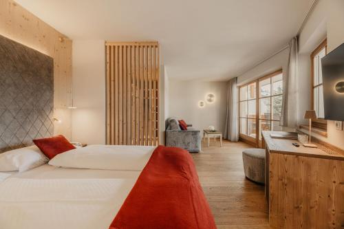 a bedroom with a large white bed and a desk at Hotel Castel Oswald von Wolkenstein in Castelrotto