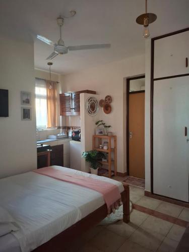 a bedroom with a bed and a kitchen at Studio Apartment, Nyali Mombasa in Mombasa