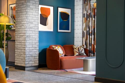 a living room with a red couch and blue walls at voco Fareham - Solent by IHG in Fareham