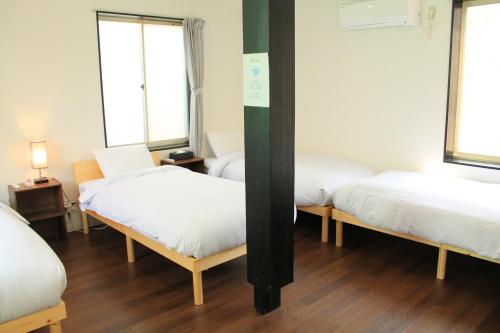 a room with three beds and two windows at Irodorinoyado Kaede Izumi - Vacation STAY 70082v in Yamanakako