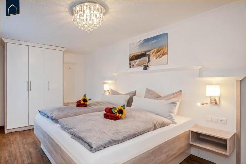 Un dormitorio blanco con una cama grande con flores. en Bungalow "Giny", en Bansin