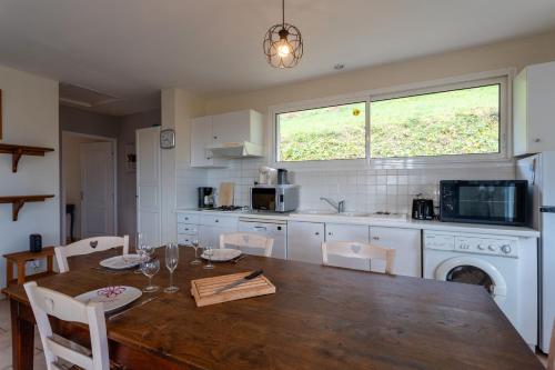 une cuisine avec une table en bois et une salle à manger dans l'établissement La maison de vacances Mathieu, à Artigues