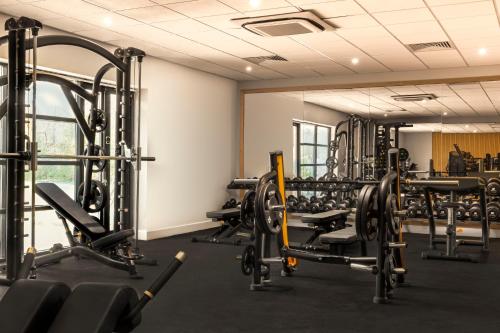 a gym with several treadmills and weights at voco Fareham - Solent by IHG in Fareham