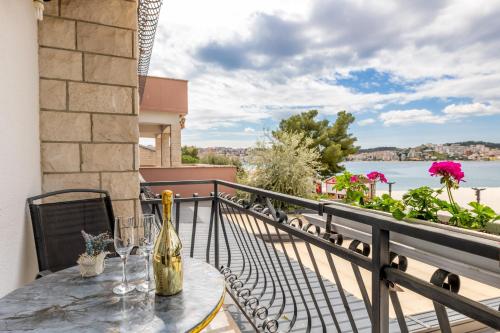 a table with wine glasses on a balcony with a view at Villa Okruk-10 meters away from the beach in Trogir