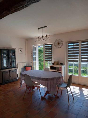 a kitchen and dining room with a table and chairs at La p'tite Maison de Mimi in Fontaine-le-Dun