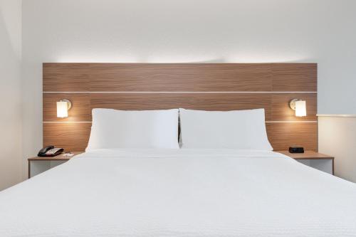 a bedroom with a large white bed with two night stands at Holiday Inn Express & Suites Moore by IHG in Moore