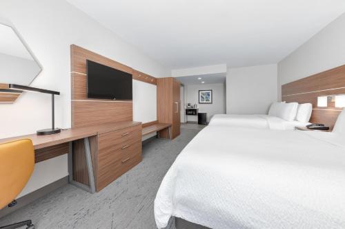 a hotel room with two beds and a flat screen tv at Holiday Inn Express & Suites Moore by IHG in Moore