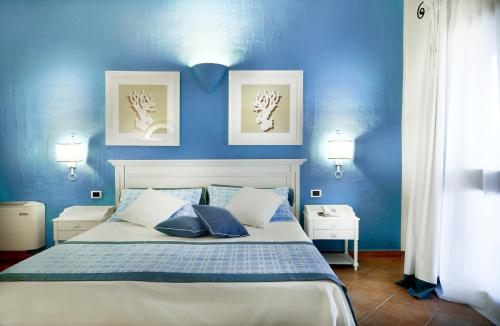 1 dormitorio azul con 1 cama con paredes azules en iGV Club Santagiusta, en Castiadas