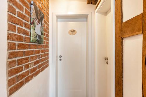 a brick hallway with a white door and a brick wall at Zeihäänger Stubb in Schwalmstadt