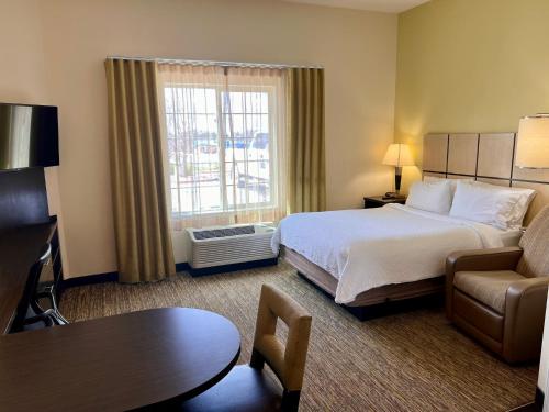 a hotel room with a bed and a couch and a table at Candlewood Suites Winnemucca by IHG in Winnemucca