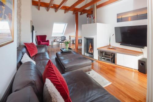 a living room with a leather couch and a fireplace at Ferienloft Inselliebe in Norderney