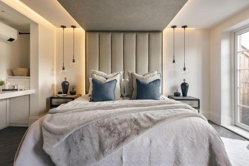 a bedroom with a large bed with blue pillows at The Sanctuary - Ridgestone in Watermillock