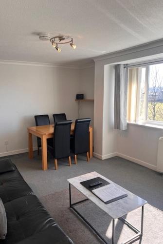 a living room with a couch and a table at Kelpies Serviced Apartments- Abbotsford in Falkirk