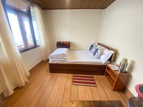 a small room with a bed and a window at Hill Garden Homestay in Uttarey