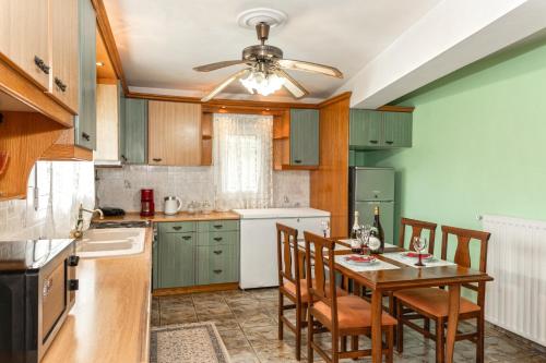 a kitchen with a table with chairs and a ceiling fan at Castle House in Áno Yerakaríon