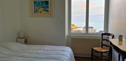 une chambre avec un lit, un bureau et une fenêtre dans l'établissement Villa SUPERBE VUE MER avec WIFI, jardin, terrasse à PERROS GUIREC - Réf 931, à Perros-Guirec