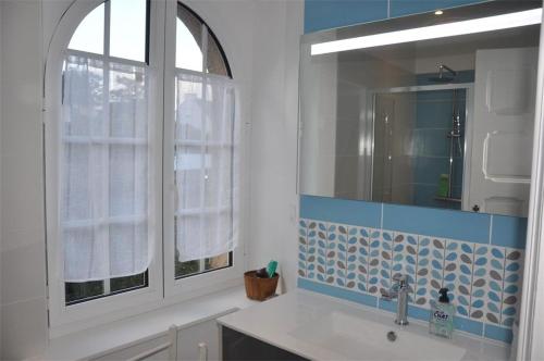une salle de bain avec un lavabo et un miroir dans l'établissement Villa SUPERBE VUE MER avec WIFI, jardin, terrasse à PERROS GUIREC - Réf 931, à Perros-Guirec