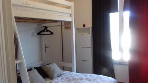 - une petite chambre avec des lits superposés et une fenêtre dans l'établissement Charmant 2 pièces, hyper-centre, Avenue de la Mer, à Cabourg