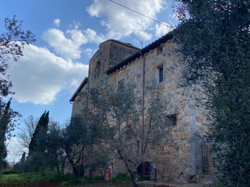 an old stone building with trees in front of it at Agriturismo la Pieve di Casabucci in Tognazza