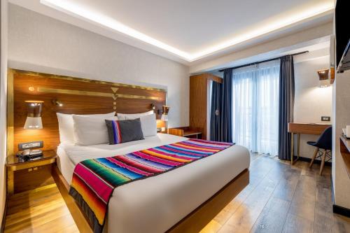 a hotel room with a large bed and a desk at Hay Hotel Alsancak in Izmir