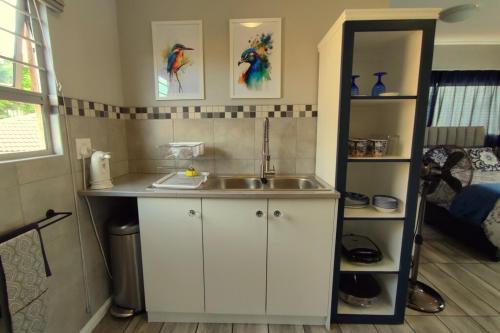 a small kitchen with a sink and a mirror at Naomi's Sky Loft Little Falls in Roodepoort
