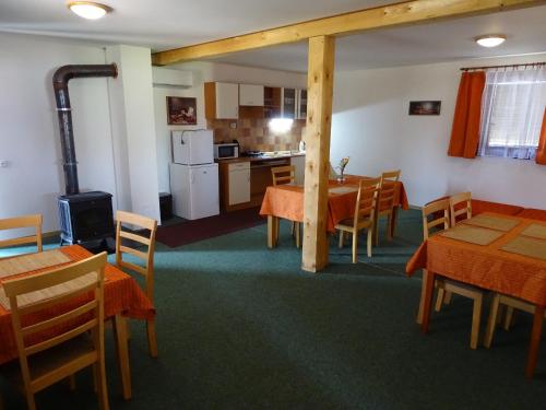 a dining room with tables and chairs and a kitchen at Ubytování Pod Vápenkami in Skalica