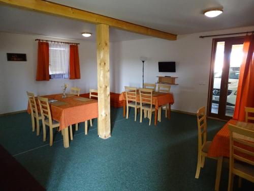 a dining room with tables and chairs and a television at Ubytování Pod Vápenkami in Skalica